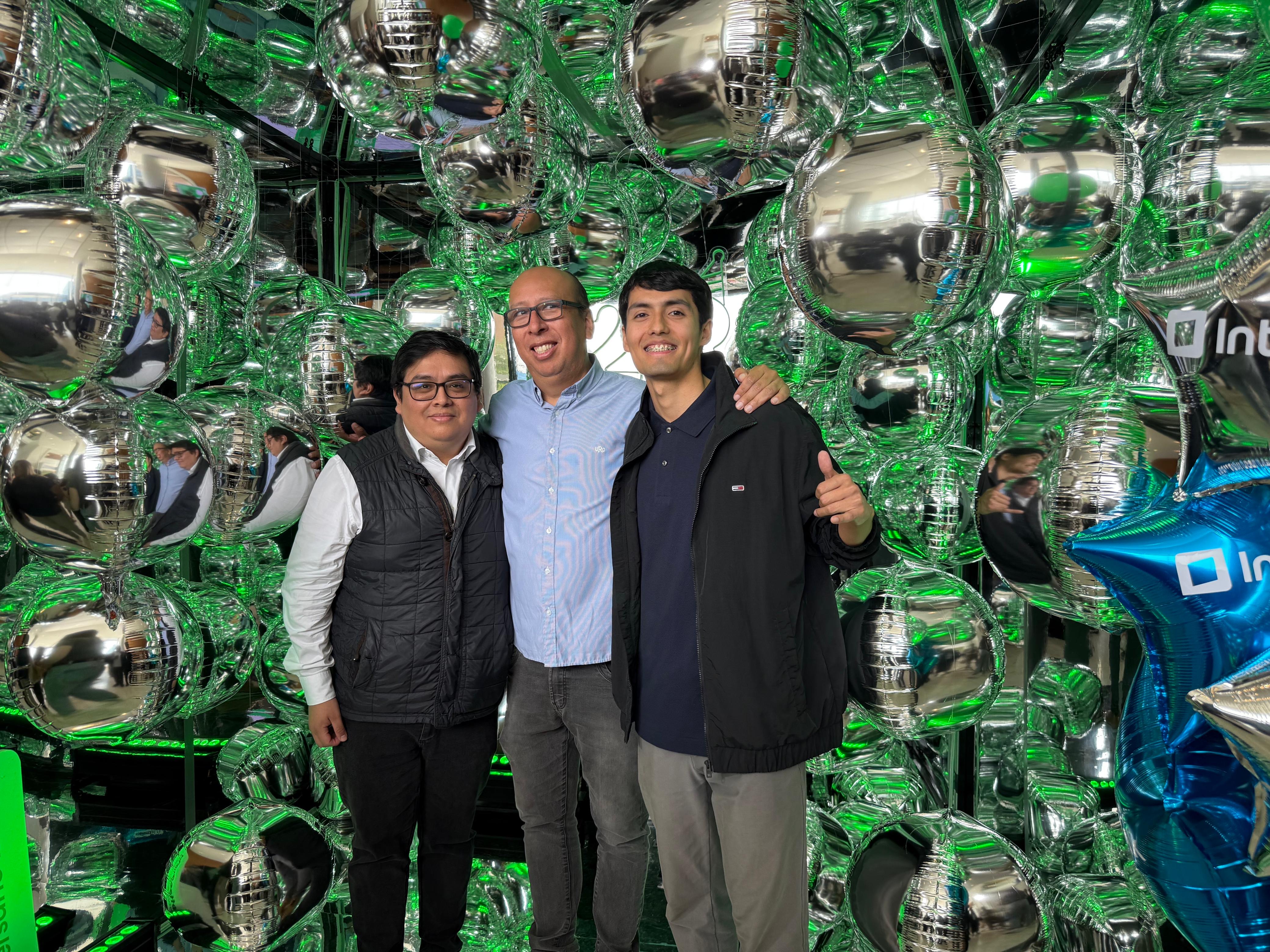 Three colleagues at an Interbank celebration with silver and green balloons